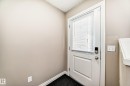 Entrance featuring a white door with a window and integrated blinds, a dark floor, and light-colored walls - 23 445 Brintnell Boulevard Nw, Edmonton, AB  - Indoor Photo Showing Other Room 