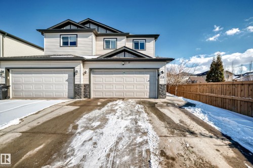The property features a two-story exterior with light-colored siding, a dark roof, and stone accents - 23 445 Brintnell Boulevard Nw, Edmonton, AB - Outdoor