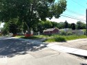 The property features mature trees, a chain-link fence, and a paved street with a sidewalk - 12072 95 Street, Edmonton, AB 