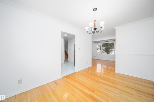 This room features polished hardwood flooring and a ceiling-mounted light fixture - 6411 149 Avenue Nw, Edmonton, AB - Indoor Photo Showing Other Room