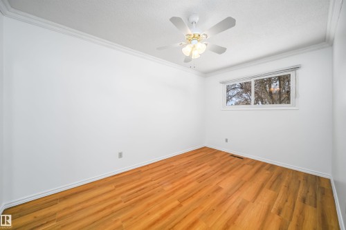 This room features hardwood flooring, white walls, and a window providing natural light - 6411 149 Avenue Nw, Edmonton, AB - Indoor Photo Showing Other Room
