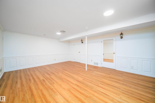 Spacious room featuring light wood flooring, white walls with wainscoting, and recessed lighting - 6411 149 Avenue Nw, Edmonton, AB - Indoor Photo Showing Other Room