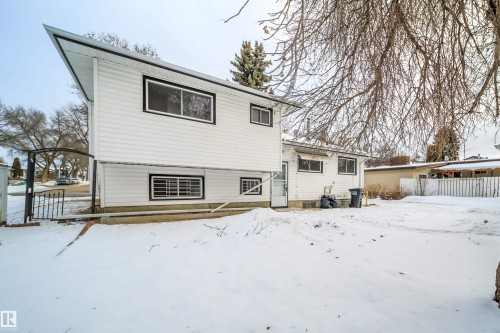 The property features white siding and black trim around the windows, with a white exterior door visible on the lower level - 6411 149 Avenue Nw, Edmonton, AB - Outdoor With Exterior