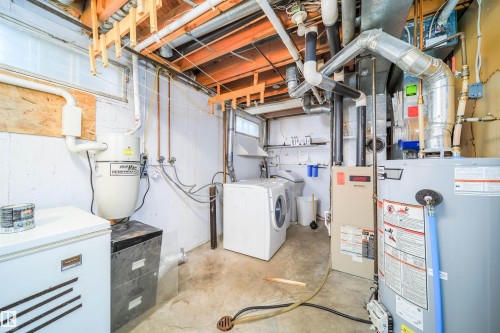 The property features a dedicated utility area, equipped with a washer and dryer, a water heater, and a furnace - 6411 149 Avenue Nw, Edmonton, AB - Indoor Photo Showing Other Room