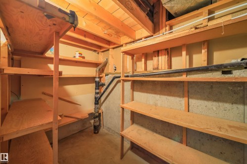 A storage area featuring exposed wood beams and shelving, with concrete walls providing a sturdy foundation - 6411 149 Avenue Nw, Edmonton, AB - Indoor