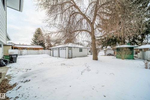 The property features a spacious backyard with a detached two-car garage and a white picket fence - 6411 149 Avenue Nw, Edmonton, AB - Outdoor
