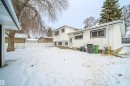 The property features white vinyl siding and a white picket fence, providing a bright exterior - 6411 149 Avenue Nw, Edmonton, AB  - Outdoor 