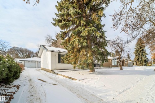 The property features a detached garage with a white overhead door and a white exterior - 6411 149 Avenue Nw, Edmonton, AB - Outdoor