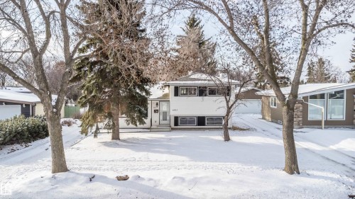 The property features a two-story exterior with a white facade and dark window frames - 6411 149 Avenue Nw, Edmonton, AB - Outdoor