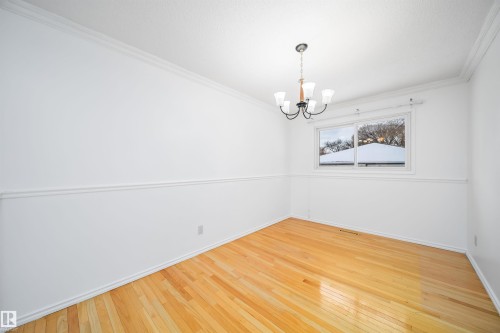 This room features hardwood flooring, crown molding, and a chandelier - 6411 149 Avenue Nw, Edmonton, AB - Indoor Photo Showing Other Room