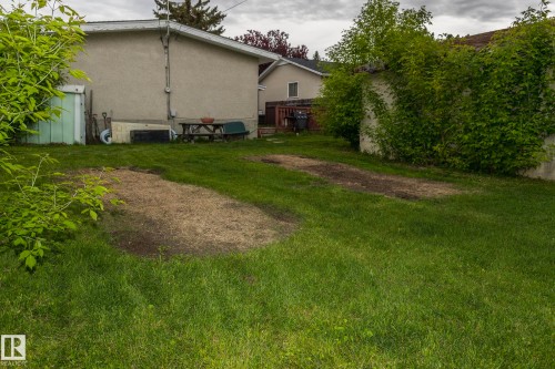 The property features a spacious lawn with established greenery and a stucco exterior - 10512 55 Avenue, Edmonton, AB - Outdoor