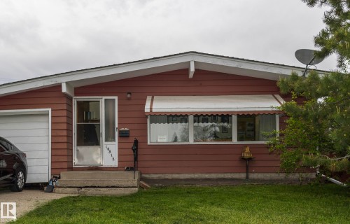 The property features a red exterior with white trim, a single-car garage, and a front lawn - 10512 55 Avenue, Edmonton, AB - Outdoor