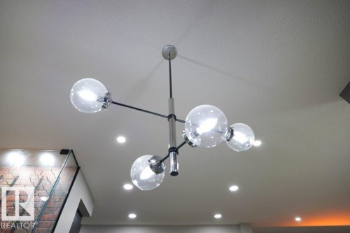 Modern ceiling light fixture with spherical glass shades and a metallic frame, complemented by recessed lighting - 266 Charlesworth Drive, Edmonton, AB - Indoor Photo Showing Other Room