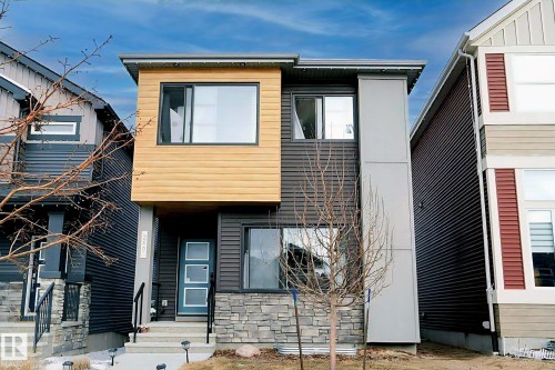 The property features modern architectural design with a blend of natural wood siding and dark-toned paneling - 266 Charlesworth Drive, Edmonton, AB - Outdoor