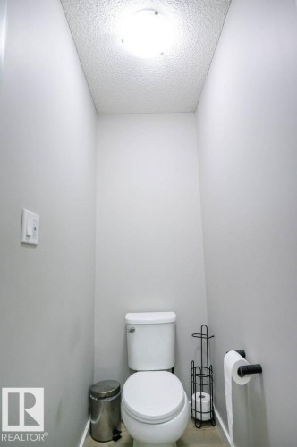 The property features a powder room with light gray walls, a white toilet, and a ceiling light fixture - 266 Charlesworth Drive, Edmonton, AB - Indoor Photo Showing Bathroom