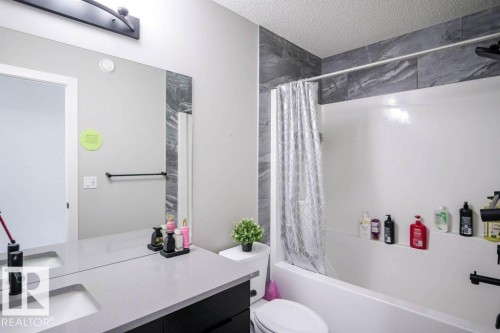 The bathroom features a vanity with an integrated sink and a large mirror - 266 Charlesworth Drive, Edmonton, AB - Indoor Photo Showing Bathroom