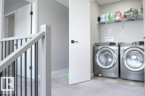 Laundry area featuring a washer and dryer, with a wire shelf located above - 266 Charlesworth Drive, Edmonton, AB - Indoor Photo Showing Laundry Room