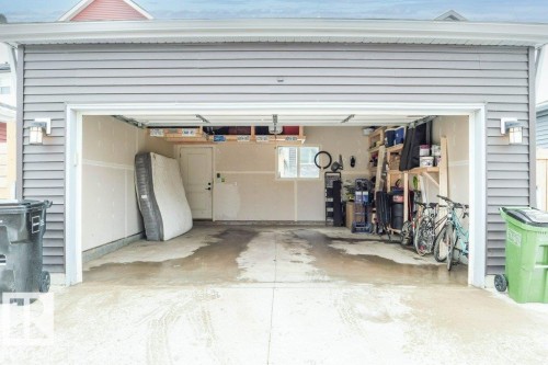 The property features an attached garage with a concrete floor, painted interior walls, and overhead storage - 266 Charlesworth Drive, Edmonton, AB -  Photo Showing Garage