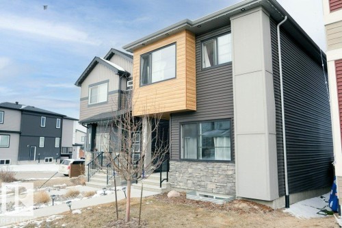 The property features a modern exterior with horizontal siding in varied colors, stone accents, and large windows - 266 Charlesworth Drive, Edmonton, AB - Outdoor