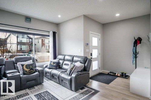 The property features a bright living area with light-colored flooring, recessed lighting, and a large window - 266 Charlesworth Drive, Edmonton, AB - Indoor