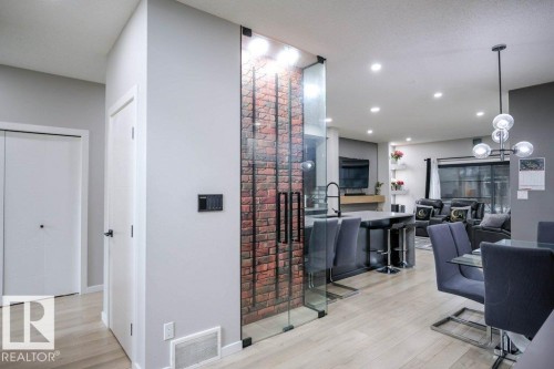 Contemporary open-concept living space featuring light-toned flooring, recessed lighting, and a modern chandelier - 266 Charlesworth Drive, Edmonton, AB - Indoor Photo Showing Other Room