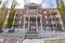 The property features a multi-story building with a brick and stucco exterior, individual balconies with white railings, and a prominent entrance with columns and steps - 416 263 Macewan Road, Edmonton, AB  - Outdoor With Balcony With Facade 