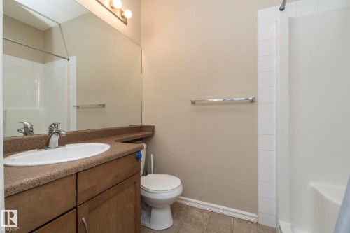 Bathroom featuring a vanity with a countertop, an integrated sink, and cabinet storage - 416 263 Macewan Road, Edmonton, AB - Indoor Photo Showing Bathroom