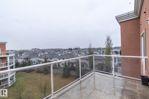 Private balcony featuring a concrete surface and glass railings, offering views of the surrounding residential area and green space - 416 263 Macewan Road, Edmonton, AB - Outdoor With Balcony With View With Exterior