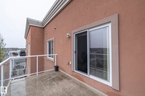 The property features a private balcony with glass panel railings and a sliding glass door, providing access to the interior - 416 263 Macewan Road, Edmonton, AB - Outdoor With Balcony With Exterior