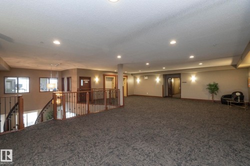 The property features a spacious landing area with carpeted flooring and recessed lighting - 416 263 Macewan Road, Edmonton, AB - Indoor Photo Showing Other Room