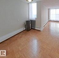 Spare room featuring baseboard heating and parquet floors - 