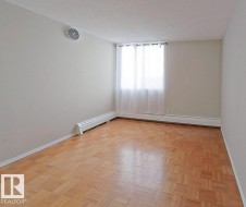 Spare room featuring parquet flooring, a textured ceiling, and a baseboard radiator - 
