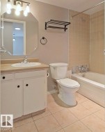 Full bath with vanity, bathtub / shower combination, and light tile patterned floors - 
