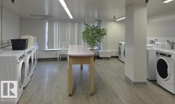 Community laundry room with washing machine and dryer and light wood-style floors - 