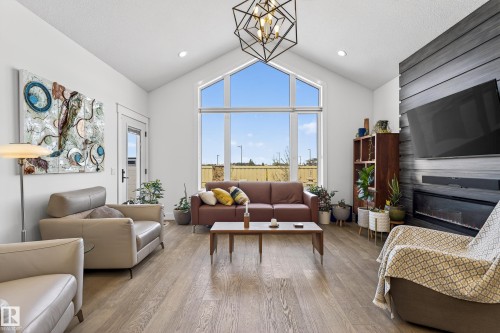 The living area features vaulted ceilings, large windows providing abundant natural light, and light-toned flooring - 45 Evermore Crescent, St. Albert, AB - Indoor Photo Showing Living Room With Fireplace
