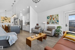 The property features an open-concept living area with vaulted ceilings, hardwood floors, and recessed lighting - 