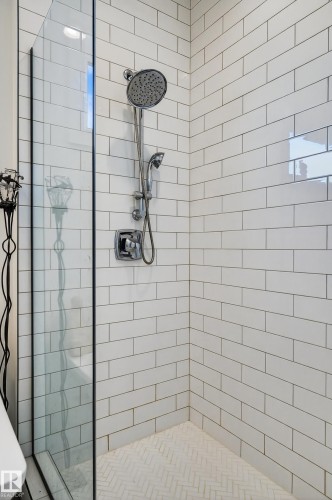 The shower features white subway tile walls, a glass enclosure, and a chrome shower head with an additional handheld shower fixture - 45 Evermore Crescent, St. Albert, AB - Indoor Photo Showing Bathroom
