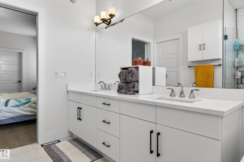 Bathroom featuring a dual vanity with white cabinetry, white countertops, and chrome faucets - 45 Evermore Crescent, St. Albert, AB - Indoor Photo Showing Bathroom