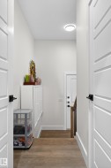 The property features hardwood flooring and white paneled interior doors with black hardware - 