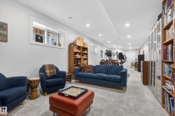 This versatile space features light gray carpeting, recessed lighting, and a white window with a view of an exterior wall - 