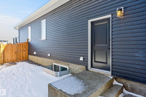 The property features dark horizontal siding, a white soffit, and a dark entry door with a white frame - 45 Evermore Crescent, St. Albert, AB - Outdoor With Exterior