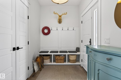 Entryway featuring two white panel doors, a built-in bench with storage cubbies, and a light-colored rug on hardwood flooring - 45 Evermore Crescent, St. Albert, AB - Indoor Photo Showing Other Room