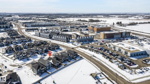 Aerial view of the neighborhood featuring residential properties with dark roofs, well-maintained streets, and nearby commercial buildings - 45 Evermore Crescent, St. Albert, AB - Outdoor With View