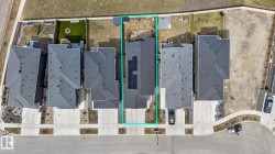 Aerial perspective of a detached residence featuring a dark shingle roof and a dedicated driveway - 