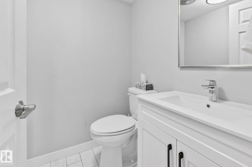 Bathroom featuring a vanity with a white rectangular sink, a chrome faucet, and a wall-mounted mirror - 17082 67 Avenue Nw, Edmonton, AB - Indoor Photo Showing Bathroom