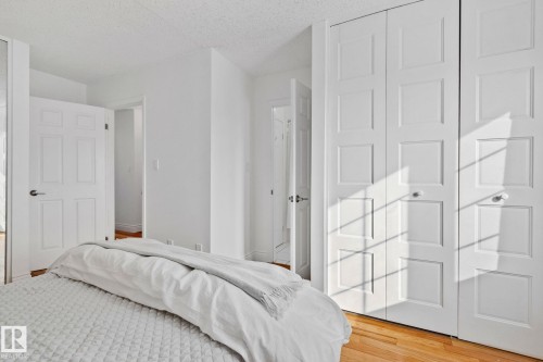 Bedroom featuring hardwood floors and white paneled closet doors - 17082 67 Avenue Nw, Edmonton, AB - Indoor Photo Showing Bedroom