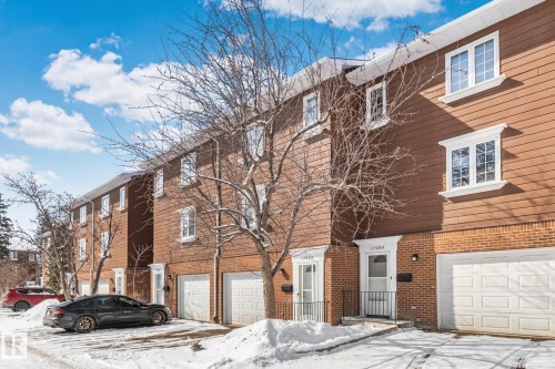 The property features a brick and siding exterior with white window frames - 17082 67 Avenue Nw, Edmonton, AB - Outdoor With Facade