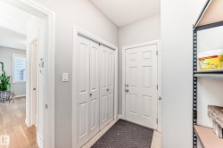 Entryway featuring a white paneled door, bi-fold closet doors, and light-toned flooring - 