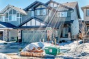 The property features a two-story exterior with a two-car garage, a covered front entrance, and a stone facade accenting the garage and front porch - 22407 99 Avenue, Edmonton, AB  - Outdoor With Facade 