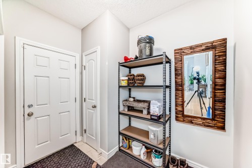 This entryway features a white paneled door, light gray walls, and a decorative mirror with a wooden frame - 22407 99 Avenue, Edmonton, AB - Indoor Photo Showing Other Room